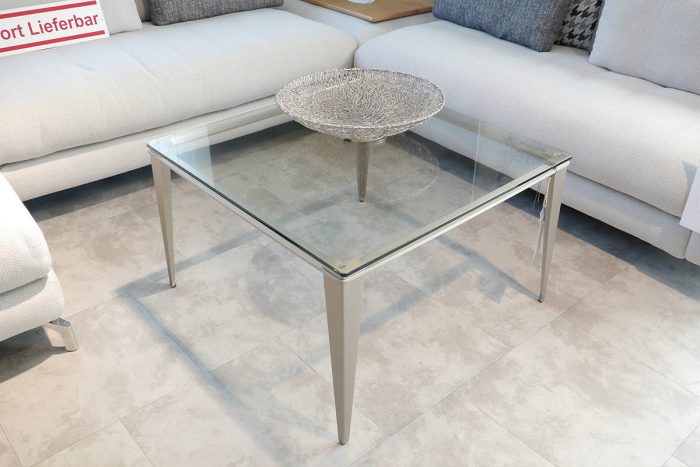 Quadratischer Couchtisch mit Glasplatte und schmalen Füßen aus gebürstetem Edelstahl