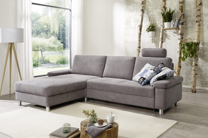 Graues Stoffsofa mit Longchair und runden Chromfüßen, sowie einer Kopfstütze