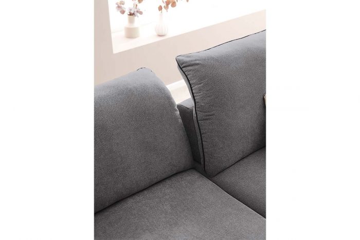 Sofa mit Sitztiefenverstellung in grauem Stoff. Die Keder ist aus schwarzem Kunstleder.