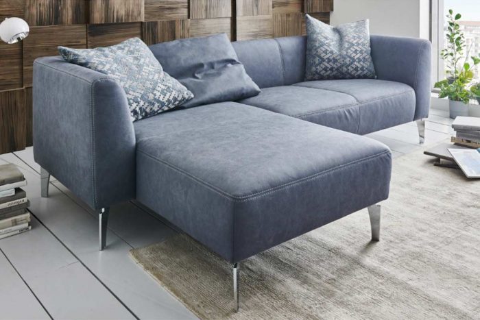 Ecksofa mit hoher Armlehne in einem zarten Blauton und mit chromfarbenen Winkelfüßen