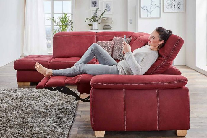 Rotes Ecksofa mit beiger Kontrastnaht und Relaxfunktion