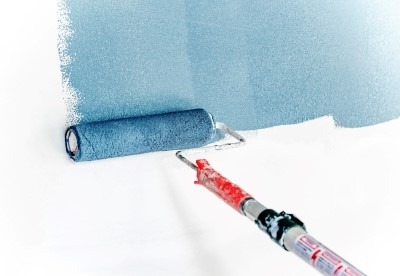 Hellblauer Anstrich einer weißen Wand mit Rollpinsel