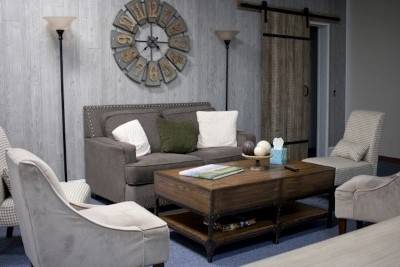 Graues Sofa mit vier Sesseln und Holztisch