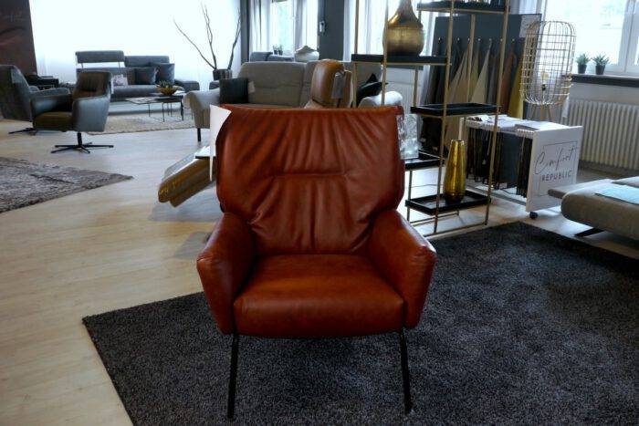 Moderner Ledersessel im roten Leder und mit schwarzen Metallfüßen
