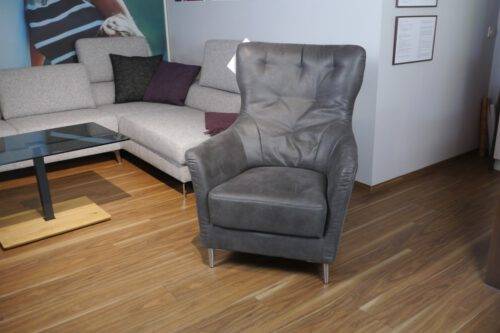 Grauer Sessel mit Steppung im Rücken und Chromfuß