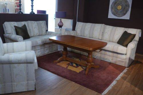 Cremefarbene Sofas mit Schabracke und Holzfuß